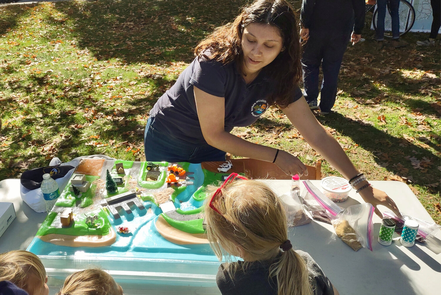Families learn about stormwater through a watershed model at the Rain Harvest Festival